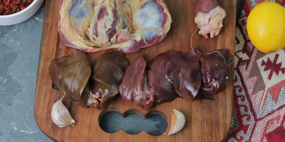 Poultry liver and hearts on a wooden board