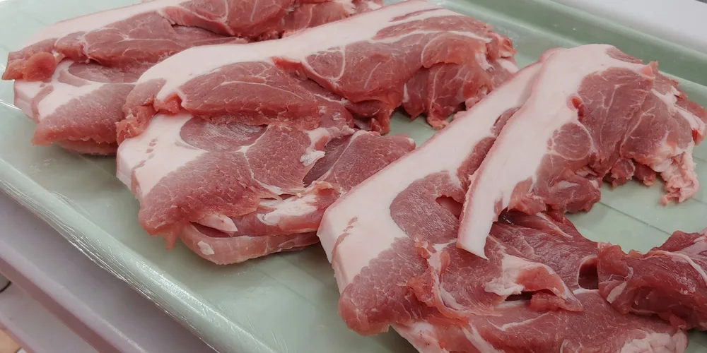 Felii de carne de porc crudă pe o tavă de măcelărie